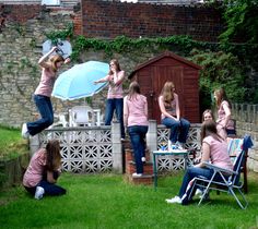 a group of women in pink shirts playing frisbee on the back deck of a house