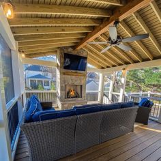 a covered porch with couches and a fireplace