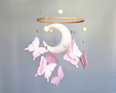 a mobile with pink butterflies hanging from it's sides and a crescent on top