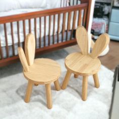 two wooden chairs sitting next to each other in front of a crib and bed