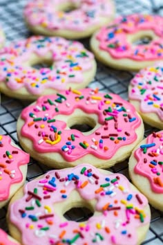 pink frosted donuts with sprinkles on a cooling rack