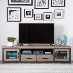 an entertainment center with two drawers and a flat screen tv mounted on top of it