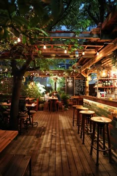 an outdoor restaurant with wooden tables and stools