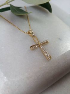 "A fine art cross in K14 made of yellow solid gold. It's decorate with lines of gold that create a very delicate cross in the middle and has small Swarovski stones throughout! A simple, minimal, inter temporal cross. Ideal for a present, engagement gift, anniversary and baptism. It is one of the most beautiful designs and can easily be worn by an adolescent or a woman of any age, who likes minimal design. The dimensions of the cross are: Height 1,26 inches (3,2 cm.) Width 0,67 inches (1,7 cm.) T 14k Gold Cross Necklace For First Communion, Gold Cubic Zirconia Crucifix Necklace, Gold Cross Necklace With Cubic Zirconia, Gold Cubic Zirconia Pendant Cross Necklace, Yellow Gold Cross Pendant For First Communion, Yellow Gold Cross Pendant Necklace For First Communion, 14k Gold Diamond Cut Cross Necklace, Gold Cubic Zirconia Cross Necklace, Diamond Cut Cubic Zirconia Cross Necklace