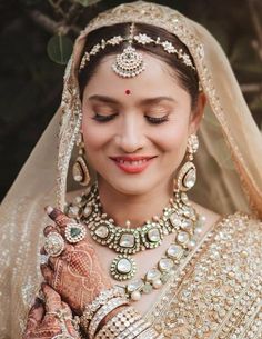 a woman wearing a bridal outfit and jewelry