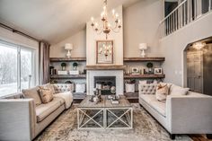 a living room with two couches and a coffee table in front of a fireplace