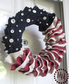 a red, white and blue rag wreath hanging on a door with the words made in america written below it