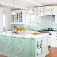 a large kitchen with an island in the middle and lots of cupboards on both sides