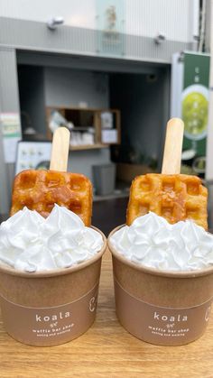 two waffles with whipped cream and caramel on top sit next to each other