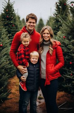 a man, woman and two children standing in front of christmas trees at the tree farm