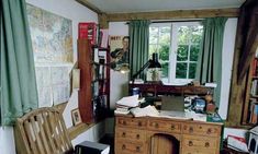 a room with a desk, chair and bookshelf filled with various items in it