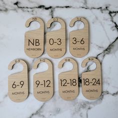 six wooden tags with numbers on them sitting on a marble countertop in front of a marble background