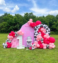 a pink house with balloons and decorations on the lawn