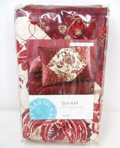 a package of red and white bedding with floral designs