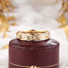 a gold wedding ring sitting on top of a wooden box in the middle of snow