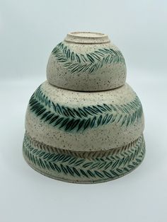 a white and green vase sitting on top of a table