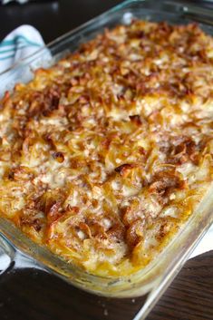 a casserole dish sitting on top of a table covered in cheese and meat