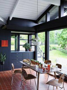 a dining room table and chairs in front of large windows