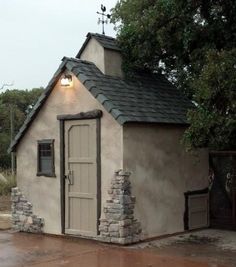 a small building with a door and windows on the outside is shown in the rain