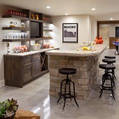 a kitchen with an island and bar stools next to it in the center of the room