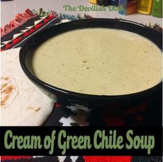 a black bowl filled with cream of green chile soup