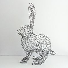 a wire sculpture of a rabbit on a white background