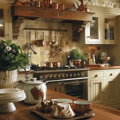 a kitchen with pots and pans on the stove top, dishes in front of it