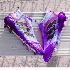 a pair of purple soccer cleats sitting on top of a white bench next to a wall