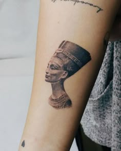 a woman's arm with an egyptian tattoo on it