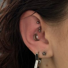 a close up of a person with ear piercings on their ears and behind the ear