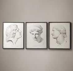 three black and white drawings of women's heads are hanging on a gray wall