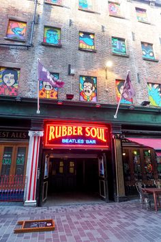 the entrance to a restaurant with colorful paintings on the building