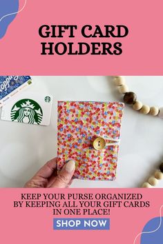 the starbucks gift card holder is being held by someone's hand and has buttons on it