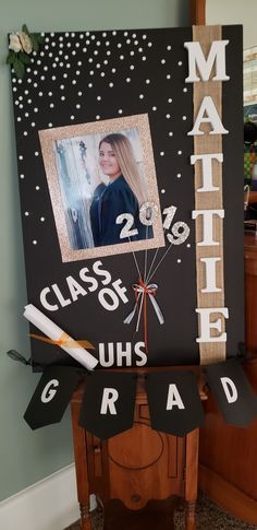 a graduation sign with a photo on it and some decorations hanging from the front door