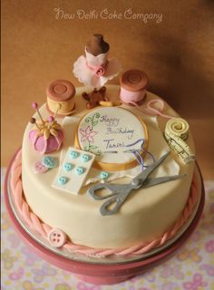 a birthday cake decorated with sewing and thread