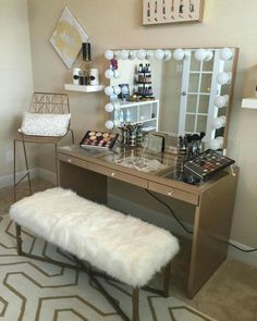 a vanity with a mirror, stool and makeup on it