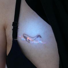 a woman's breast with a small tattoo on the left side of her stomach