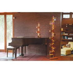 a living room filled with furniture and a grand piano in front of a brick wall