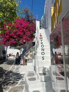 people are walking up and down the stairs in front of shops on a sunny day