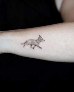 a small fox tattoo on the arm