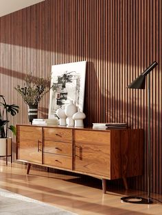 Midcentury living room with an acacia sideboard, abstract art, vases, wood floors and a vertical walnut wood slat accent wall Wood Panel Living Room, Mid Century Wood Paneling, Wood Slat Ceiling, Walnut Wall, Mill House, Minimalist Living Room Design, Design Homes, Wood Slat Wall, Wall Panelling