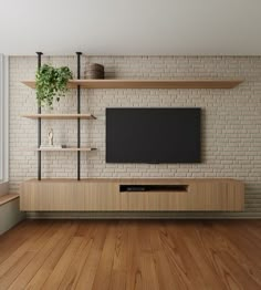 a tv is mounted on a brick wall in a room with wooden floors and shelves