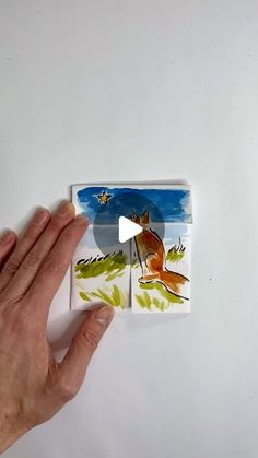 a hand is holding up an image of a fox