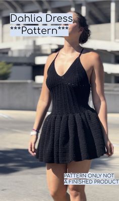 a woman in a black dress walking down the street