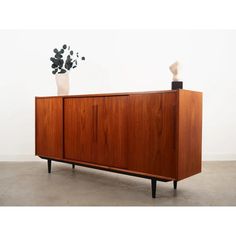 The sideboard was made in the 1970s, Danish production.  The structure is covered with teak veneer. The legs are made of solid wood stained black. The surface has been refreshed. Inside, the space has been filled with three practical height-adjustable shelves. The furniture has a practical sliding door solution, which reduces the need to leave a large free space in front of the furniture, while not restricting access to the interior. An additional feature is the versatile bar, which features a decorative mirror and two non-adjustable shelves.  Condition: Refreshed surface. Minor scratches and restored veneer losses are visible. Larger signs of use are always visible in the photos. Product ready to use.  *For safety reasons, the furniture may have its legs unscrewed and the sliding doors an Dark Wood Sideboard, Teak Sideboard, Timeless Decor, Decorative Mirror, Teak Furniture, Free Space, Sideboard Buffet, Adjustable Shelves, Furniture Pieces