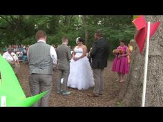 the bride and groom are walking down the path to their wedding ceremony in the woods