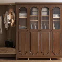 a large wooden cabinet with glass doors in a room next to a bench and coat rack