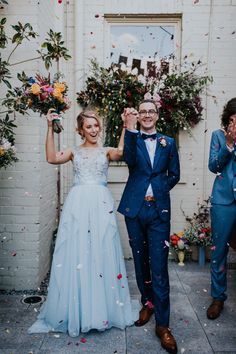 a bride and groom are walking through confetti