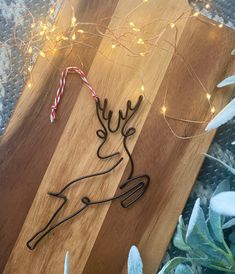 a wooden cutting board topped with a metal reindeer