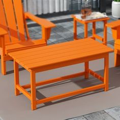 three orange chairs and a table sitting on a tile floor next to a potted plant